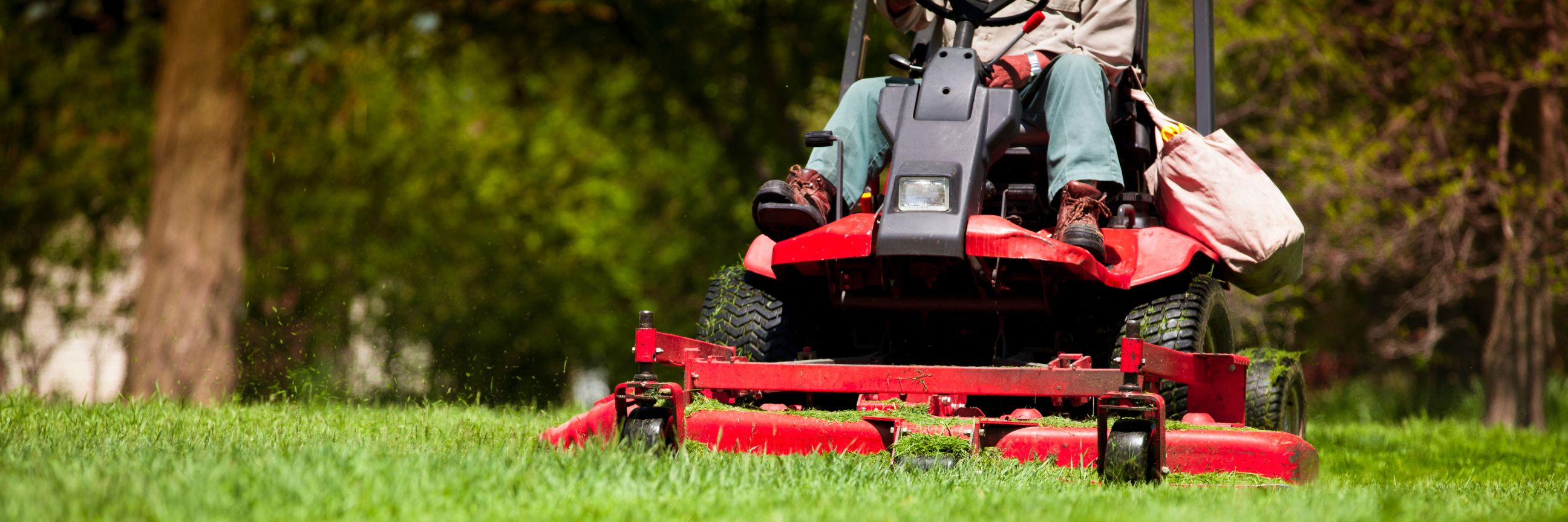 Person, die auf einem Rasentraktor sitzt und mäht