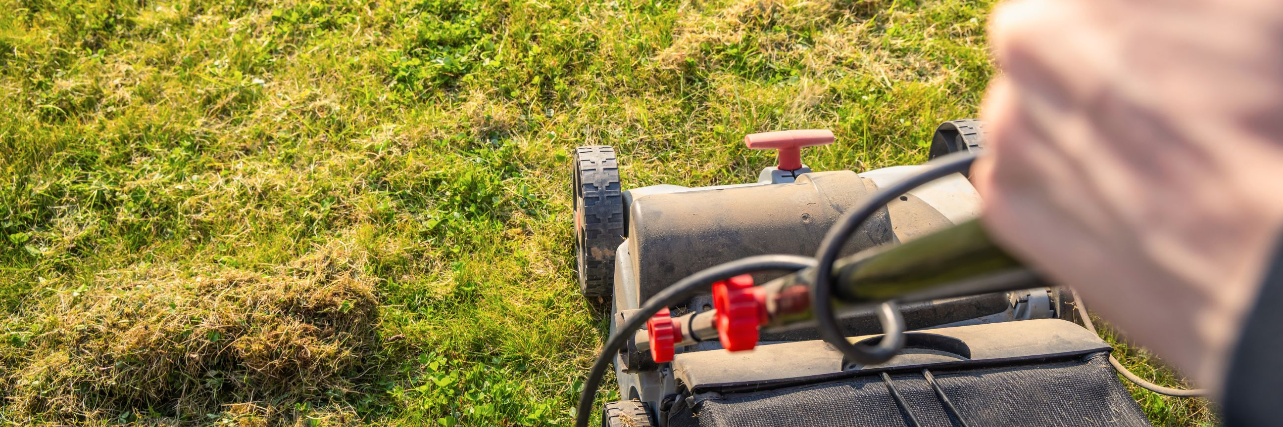 Person, die einen Rasen vertikutiert