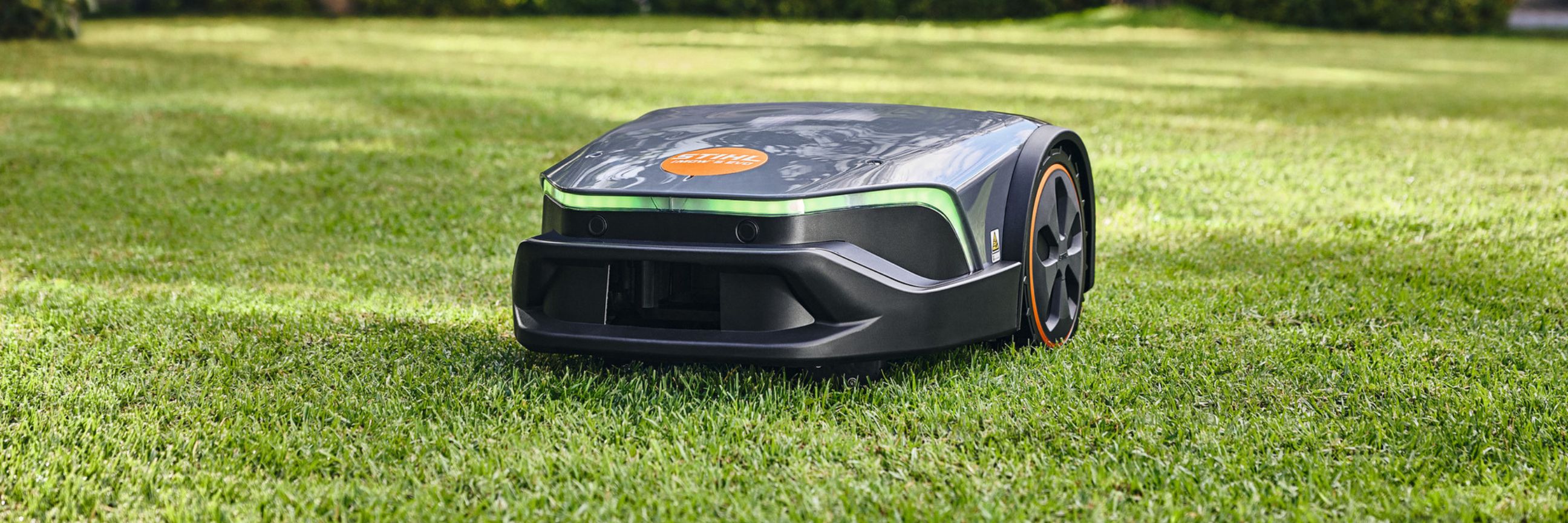 Rasenmaehroboter von Stihl faehrt ueber eine Wiese